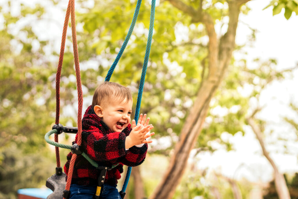 cute baby clapping on a swing in a playground 2025 03 23 18 46 59 utc